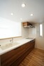 キッチン No.22-5_キッチン（撮影_2022年3月）料理をしながら、リビングダイニングを見渡す設計の対面キッチン。背面キャビネットの収納量に期待。加えて洗面室へのダイレクト動線が家事動線を楽にするポイント。