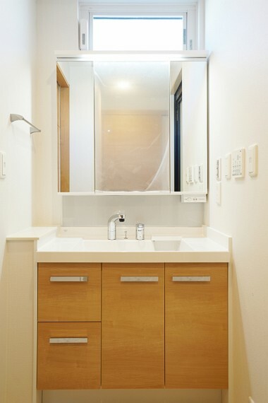 洗面化粧台 No.22-5_洗面（撮影_2022年3月）カジュアルなライト色の扉の幅が広い洗面台がうれしい。ミラー収納に加え、洗面室の壁面収納もポイント。キッチンからの横の動線が家事の最大効率化に期待。