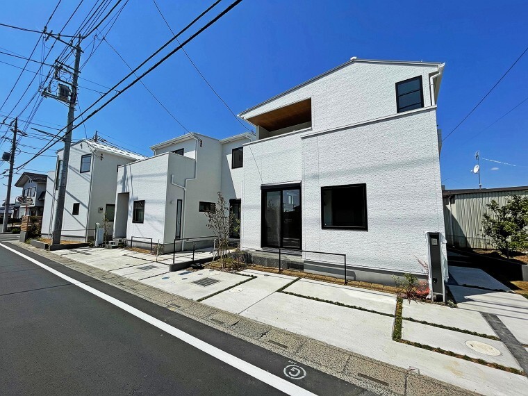 現況外観写真 青空と鮮やかなコントラスト。白を基調とした美しい街並み。 シンボルツリーと調和する印象的なファサード。青空とのコントラストに目を奪われる、ホワイトを基調とした外壁。四季折々の植栽やスタイリッシュな窓が彩を添え、シンプルにして変化を持たせた街並みの造形が、快適で個性豊かな暮らしを物語ります。