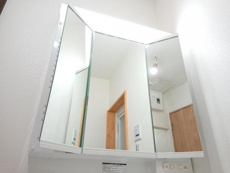 洗面化粧台 【同仕様写真】交換予定の新品洗面台は三面鏡になっています。鏡の裏に化粧品を収納できるだけでなく、毎朝の身だしなみチェックも後ろまで見ることができるので便利です。照明も左右に付いているのでとても明るいです。
