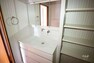 脱衣場 収納スペースがたっぷりな洗面室です。三面鏡付きの洗面台で、鏡の裏、ボウルの下に加え、洗面台横に棚が設けられており、細々した物から大きな物までたくさん収納できます。