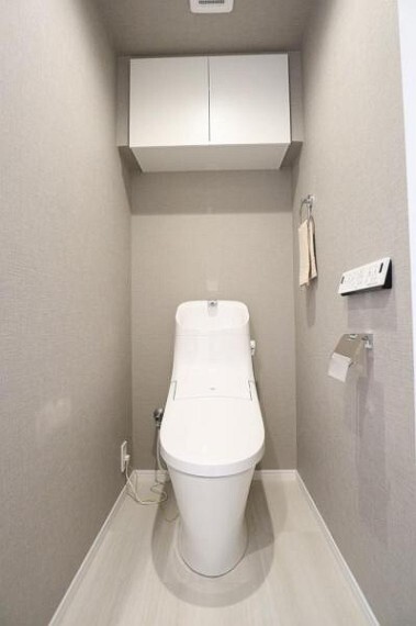 トイレ 白を基調にした清潔感のあるトイレには、便利な収納棚を設置。