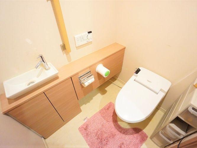 トイレ タンクレスのトイレでゆったりとした空間になっています。別途で手洗いがあり、収納スペースも沢山あります。手摺も付いているので足腰が弱っているときでも安心ですね。