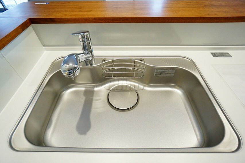 キッチン 大きな鍋などもラクラク洗えるワイドサイズを採用。排水口が奥なので水の流れもスムーズです。浄水器内蔵型シャワー水栓つき。
