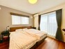 洋室 8.5帖の主寝室は、大型のベッドを入れても余裕のある空間。東南角部屋で、朝日が差し込む快適空間