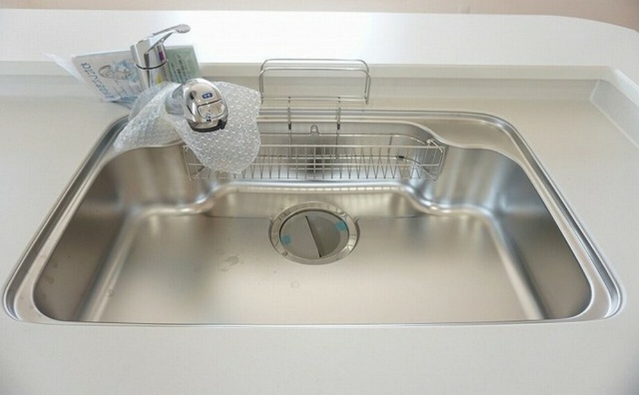 キッチン 同仕様写真。大きめの鍋も洗える使い勝手の良い異形シンク。水はねの音や食器が当たる音を大幅に軽減する静音仕様。