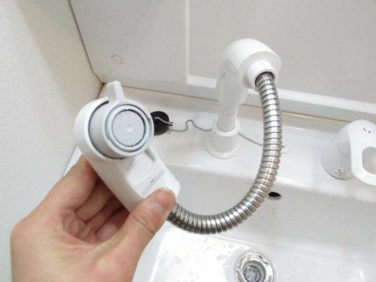 【同仕様写真】洗面台水栓は、伸縮するシャワーホースで水汲みやお手入れも簡単。水栓が壁面についているため、水たまりができず、汚れにくい構造です。