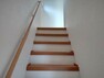 【リフォーム済】2階に続く階段です。階段の踏板は床重ね張りを行い、壁・天井クロス張替え、照明器具交換を行いました。