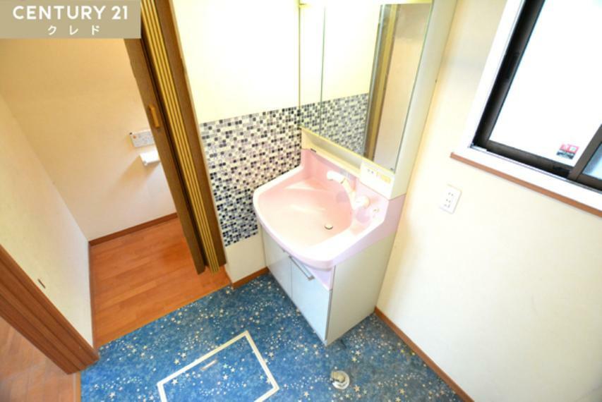 ブルーモザイクタイルの壁と星柄の床がオシャレな洗面室！ピンクの可愛らしい三面鏡付洗面化粧台完備！鏡裏に小物を収納できるスペースがあります！オシャレなだけではなく機能的だと嬉しいですね！
