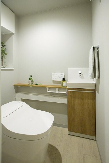 トイレ スタイリッシュなタンクレスの節水型・温水洗浄便座付トイレ。手洗いカウンター付き。