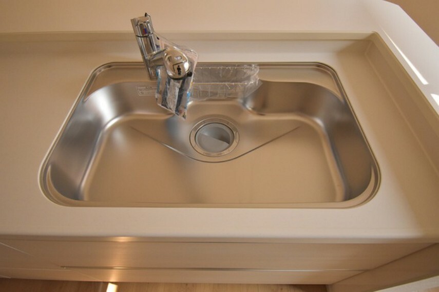 キッチン 浄水器一体型水栓付。大きめの鍋も洗える使い勝手の良い異型シンク。水はねの音や食器が当たる音を大幅に軽減します。カウンターはインテリア性に優れた人造大理石製。