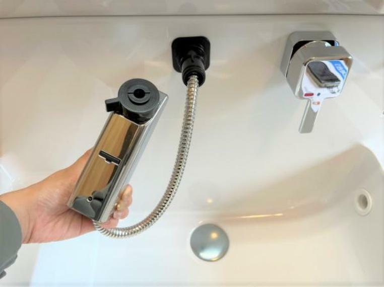 洗面台水栓は、伸縮するシャワーホースで水汲みやお手入れも簡単。水栓が壁面についているため、水たまりができず、汚れにくい構造です。