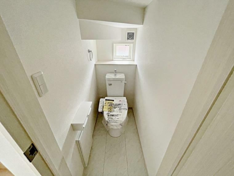 トイレ 1階の階段下のデッドスペースを利用した温水洗浄機能付きトイレです。小窓があり空気の入れ替えもできるので明るく清潔です。2階にも小窓付き温水洗浄機能付きトイレを設置しています。