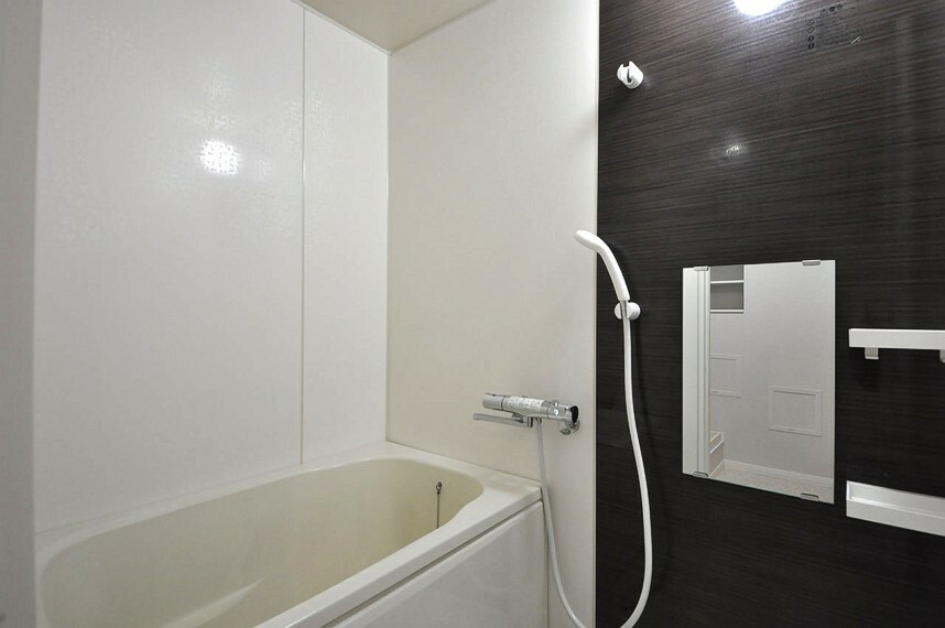 浴室 ダークブラウンのアクセントパネルがシックなバスルーム。シャワーカランや鏡を新調しました。