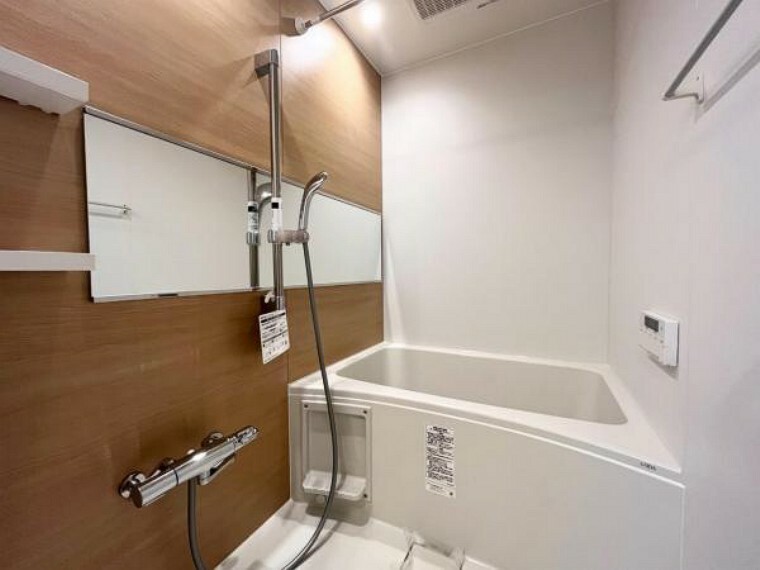 浴室 限られた空間を広く見せるワイドミラーを採用したバスルーム。アクセントパネルで落ち着きのある雰囲気を演出