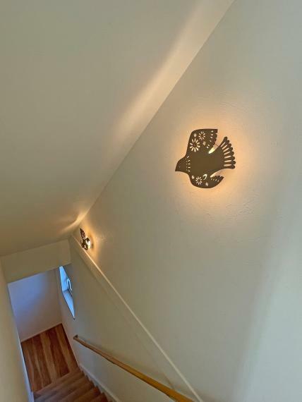 階段の照明:WCのアクセントクロスから飛んできた様な小鳥の間接照明