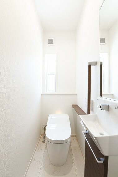 トイレ 白を基調とした清潔感のある明るいトイレ空間は広々としていて気持ち良く、思わず長居したくなります。ミニ手洗いとキャビネット付きなので掃除道具や日用品の収納にも困りません。（4号棟）