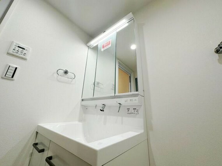 洗面化粧台 洗面台には目線に合わせた大きい鏡を採用。身だしなみを整えやすい事はもちろんですが、鏡の後ろに収納スペースを設ける事により、散らかりやすい洗面スペースをすっきりさせる事が出来るのも嬉しいですね。