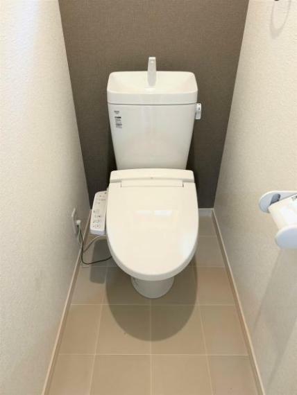 【リフォーム後】トイレはLIXIL製の温水洗浄便座に新品交換しました。室内の壁天井クロスの張替も行ったので、清潔感のある空間に生まれ変わりました。