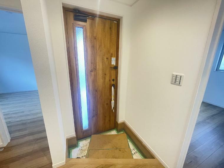 玄関 木目調の扉があたたかい雰囲気を作り上げます、明るい玄関スペースです