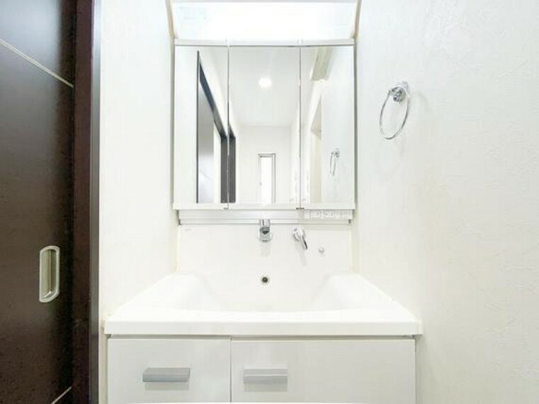 洗面化粧台 清潔感のある白を基調とした洗面化粧台です。三面鏡の裏にある収納で細々したものをしっかり片づけることができます。