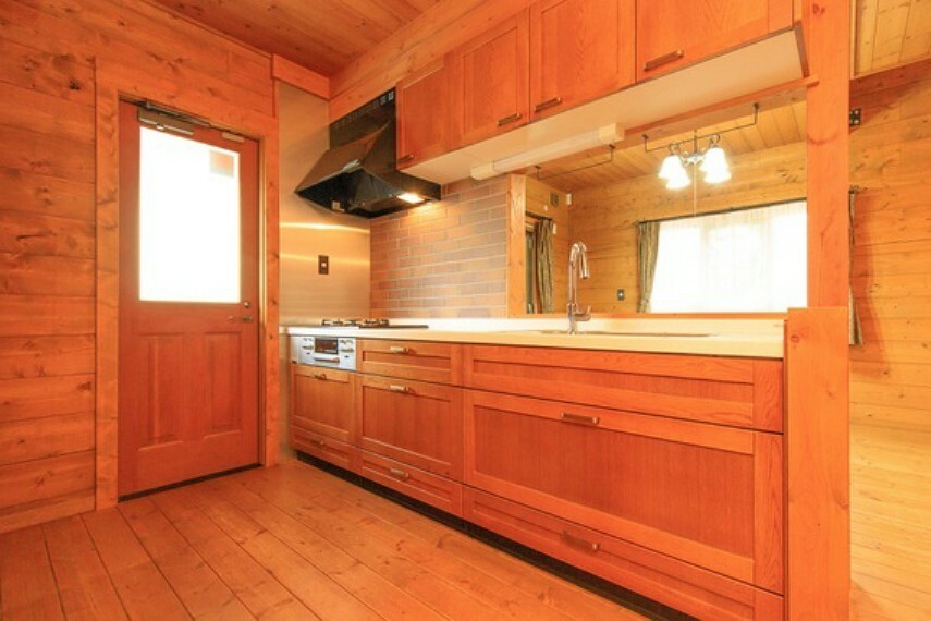 キッチン 木の色合いに、白の天板がよく映えるキッチンは、奥のものが取り出しやすいスライド式収納を採用。