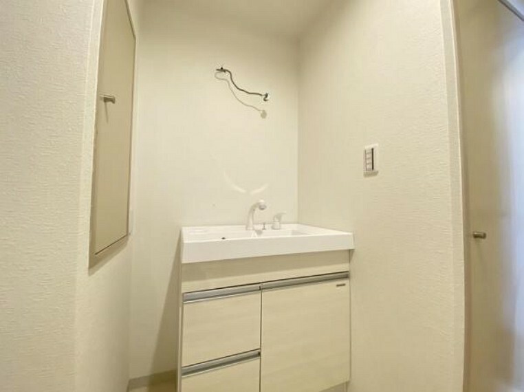 洗面化粧台 三面鏡の付いた洗面化粧台は、鏡面裏側にも機能的な収納を配置。（リフォーム中）