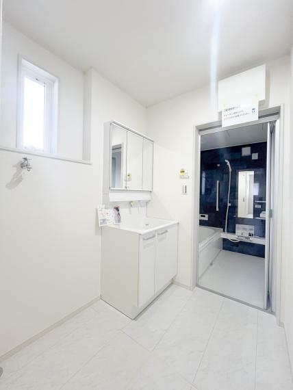 脱衣場 洗面所にはお客様に快適に過ごしていただけるよう、しっかりとした広さを確保してあります。 白色のフローリングで清潔感のある明るい空間となっております。