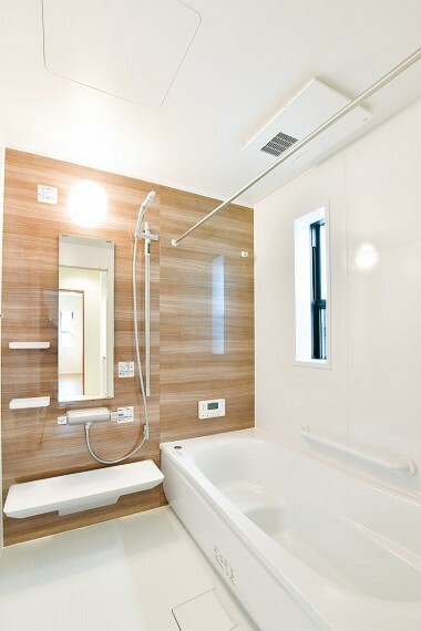 清潔感あるホワイトを基調とした空間に、木目調のダークブラウンの壁面をアクセントに。温かみが感じられ、ほっとできる色合いは、のんびりくつろぐ浴室にぴったりです。（2号棟）