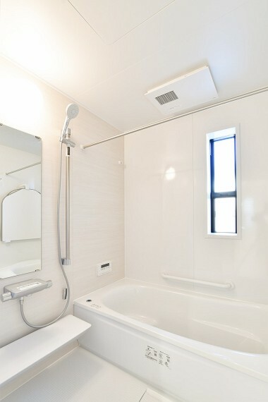 白を基調とした清潔感あふれる空間。存分にくつろげるよう設計されたバスタブで、1日の疲れをとってリセットしましょう。雨の日や夜の洗濯にも重宝する浴室乾燥暖房機付きです。（1号棟）