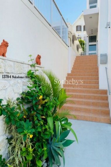 現況写真 沖縄の守り神であるシーサーや鮮やかな植栽がお迎えするエントランス。