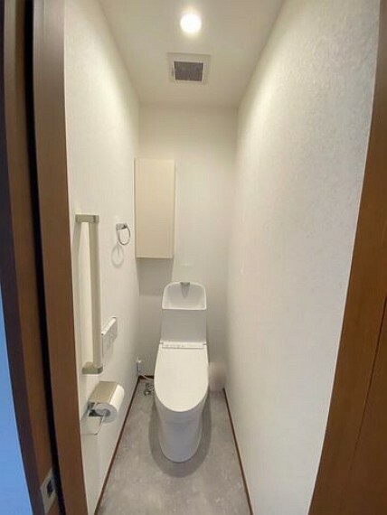 2階トイレは手洗い付きのハイシルエット。ペーパーホルダーにはスマホや眼鏡が置けるコンパクトな棚付き。吊戸棚にはトイレットペーパーの予備やタオル、掃除用品などが収納できます。
