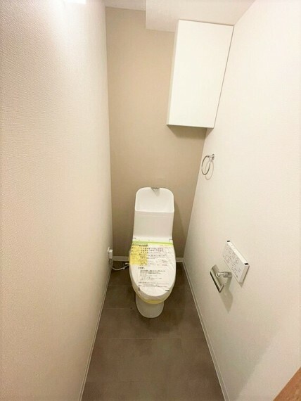 清潔感溢れる温水洗浄便座付きのトイレです。トイレ周りで使う物の収納に便利な上部吊戸棚付き。