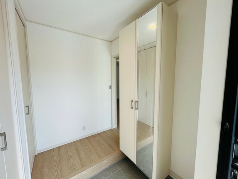 玄関 姿見付きのシューズボックス、白を基調とした明るい玄関ホールです。