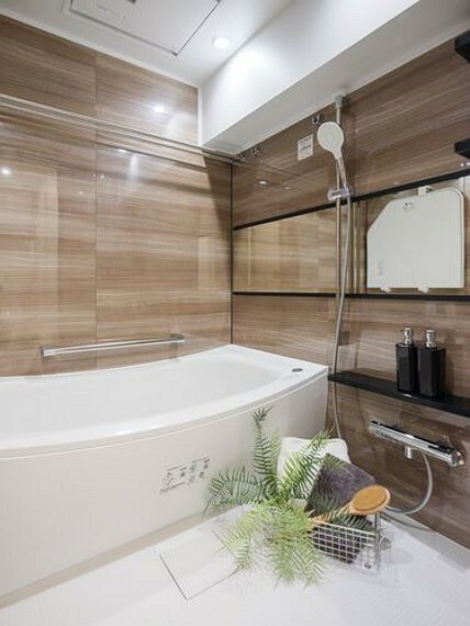 浴室 美しいカーブと全身を包み込むような入浴感が特長の浴槽が魅力のバスルームです。光沢感のある木目調タイルによって、より一層くつろぎの空間が演出されます。