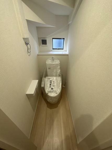 トイレ 1階　トイレ　換気扇、窓、タオル掛け、温水暖房便座付きのトイレです