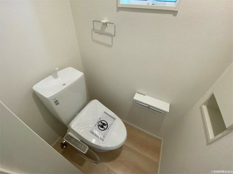 トイレ 1Fトイレ。タオル掛けや扉付きの収納など設備の揃ったトイレです
