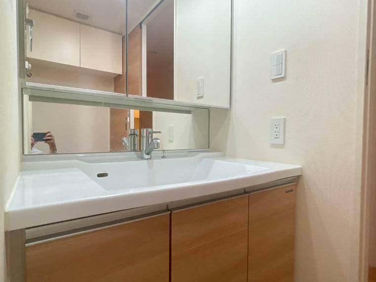 ＜三面鏡の洗面台　:洗面台＞見やすくて使いやすい三面鏡を備えた洗面台は、お肌のお手入れなどのスキンケアを施すときに適しています。収納スペースも多く設置。シンプルな空間を彩っています。