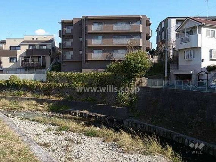 【その他】敷地の西側は千里川に面しています。周辺にはマンションや一戸建てが立ち並んでいます。