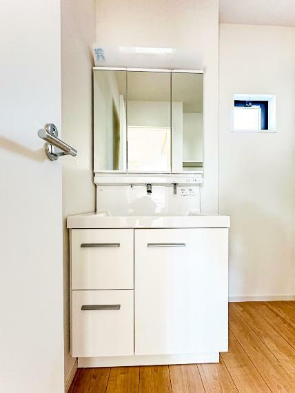洗面化粧台 【Powder room】大きく見やすい三面鏡で清潔感ある洗面台は、身だしなみチェックや肌のお手入れに最適です。（1号棟）