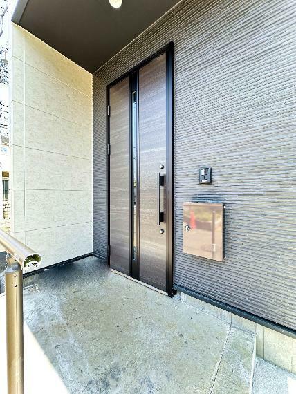 玄関 【Entrance】家の顔となる玄関は、高いデザイン性が求められます。高級感と断熱性、防犯性に優れた玄関ドアを標準装備。ピッキング対策のセキュリティサムターン等、防犯に考慮しました。（1号棟）