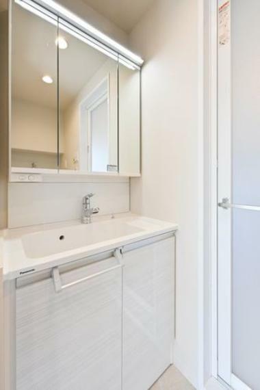 清潔感のある明るい雰囲気の洗面室です。三面鏡の裏は収納スペースがあります。