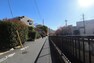 現況写真 物件の西側前面道路（北側から）。 川沿いで日当たり・風通しに優れています。東急池上線石川台駅から徒歩9分、大井町線や目黒線も利用でき多方面への移動に便利な立地です。