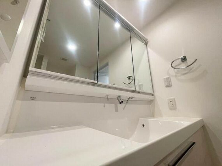 洗面化粧台 清潔感のある室内はホテルのような上質な気品あふれる空間を創造しております。使いやすい三面鏡の中やベースキャビネットには収納スペースもたっぷり。手入れしやすい人造大理石のボウルも素敵です。