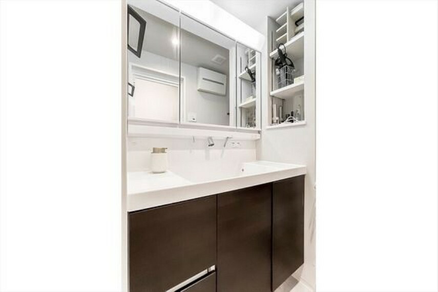 三面鏡付きの洗面台。鏡の裏、ボウルの下に加え、洗面台横にも収納スペースがあるため、化粧品、歯ブラシ等の小物やバスタオル等を隠して収納できます。