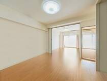【リビング】建具とフローリングの優しい木目がナチュラルで明るい空間を演出しています。※画像はCGにより家具等の削除、床・壁紙等を加工した空室イメージです。