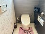トイレ 温水洗浄便座機能付きトイレです。タンクレスですっきりとした空間。クロスはシックで落ち着いた深い色のクロスに花柄のクロスが対比的。床はお掃除がしやすく棚もついている為、掃除用品等収納できます。