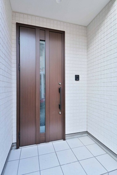 玄関 洋風タイルを使用したお洒落な玄関。木のぬくもり感じられるデザインの玄関ドアです。明るく広い玄関が出迎えてくれます。