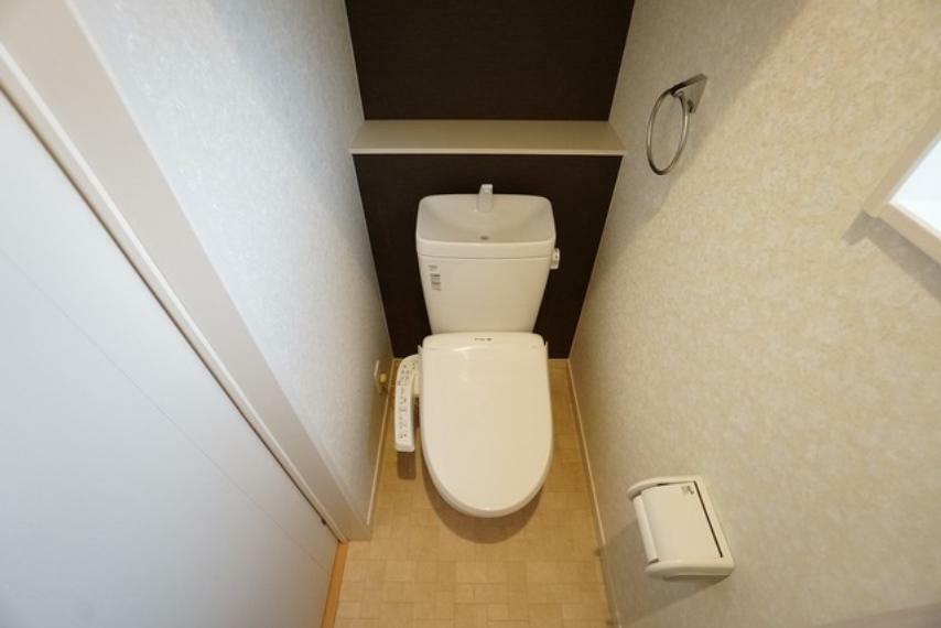 トイレ 玄関近くにある温水洗浄機付トイレです。節水機能もあるので、安心して使えますね。棚やタオル掛けも設けています。