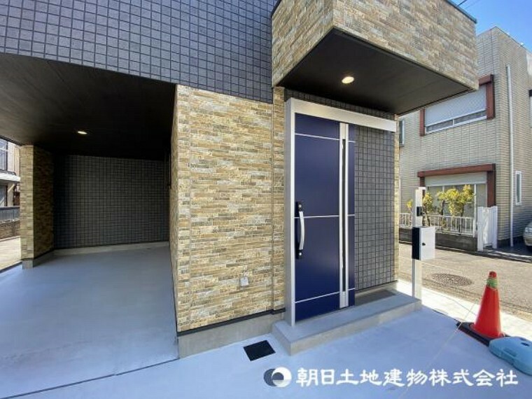 玄関 省スペースを実現するスライド式玄関ドアを採用！鮮やかなブルーの玄関ドアが建物の良いアクセント！